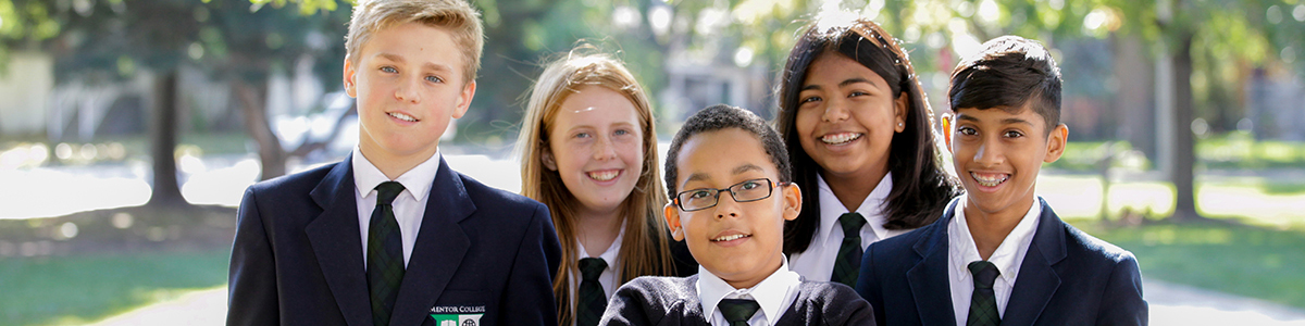 A group of Intermediate Division students outside on the field, smiling at the camera