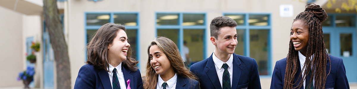 Four High School students talking, walking, smiling