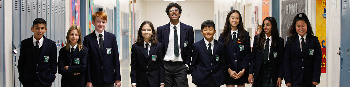 A group of nine Intermediate students in the upper main hallway at the Main Campus