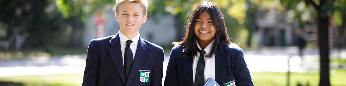 Grade 8 boy and girl in blazers in front of the Main Campus
