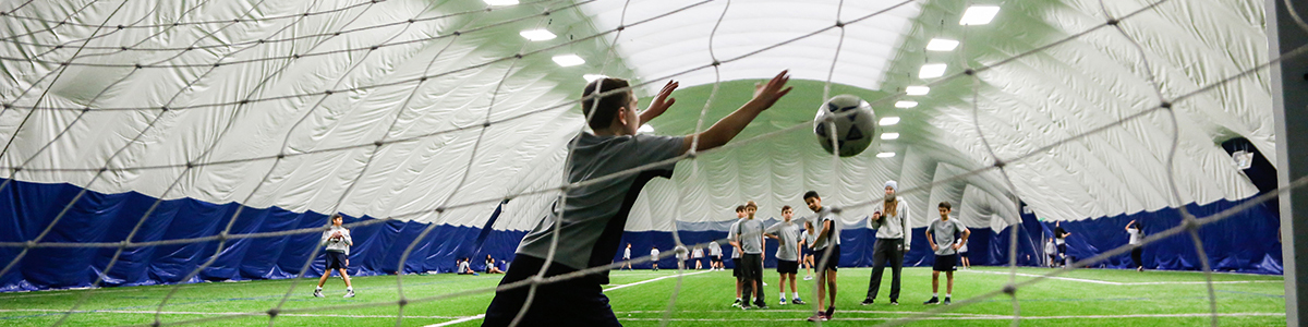 Grade 7 boys playing indoor soccer in the dome